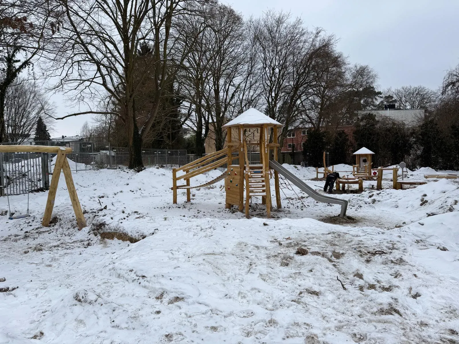 Holz-Spielanlage mit Turm, Rutsche und Schaukeln, montiert von Moshrif Spielplatzbau in Hamburg
