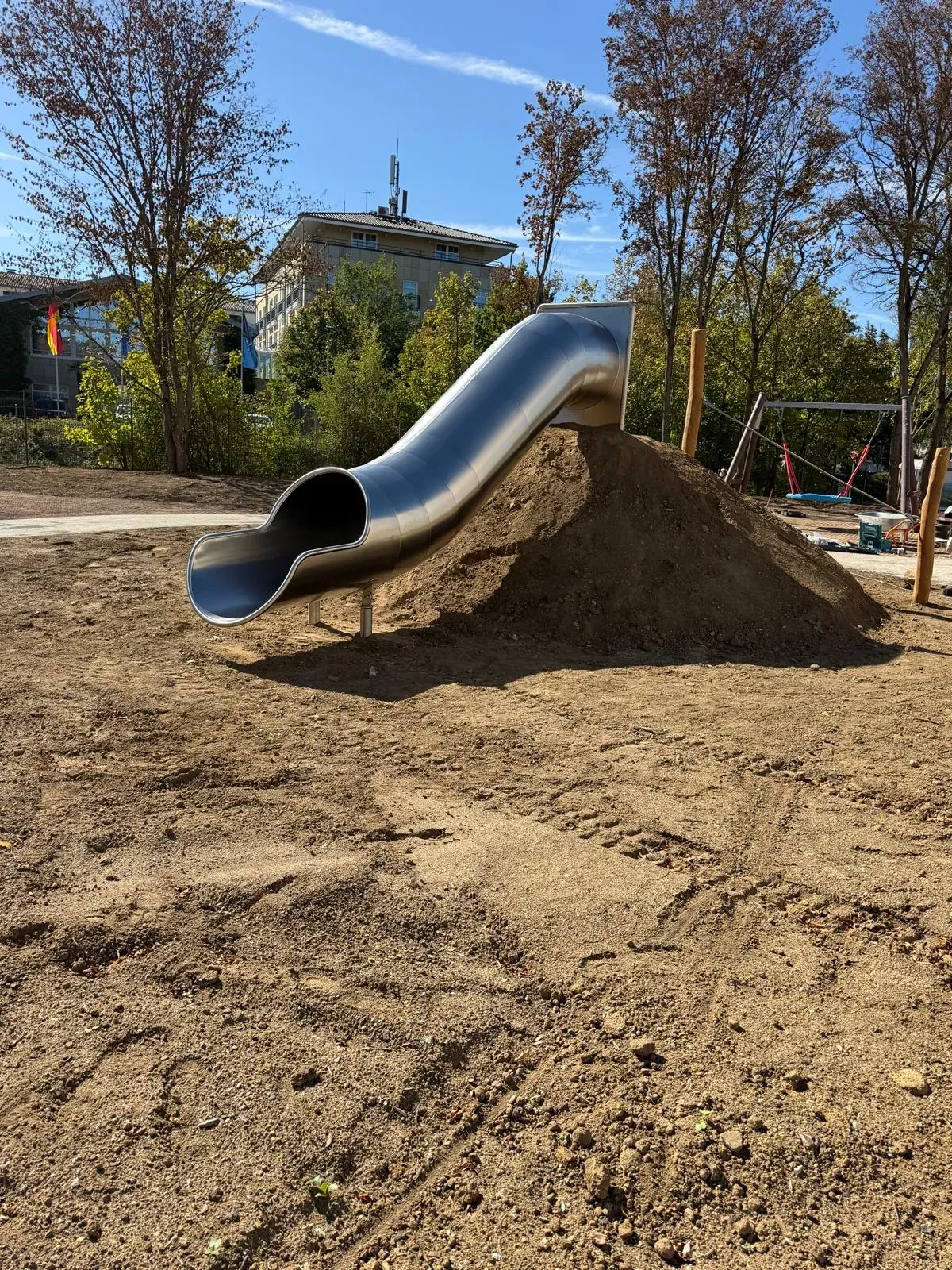Röhrenrutsche am Hügel und Rundbank, montiert von Moshrif Spielplatzbau in Bad Vilbel