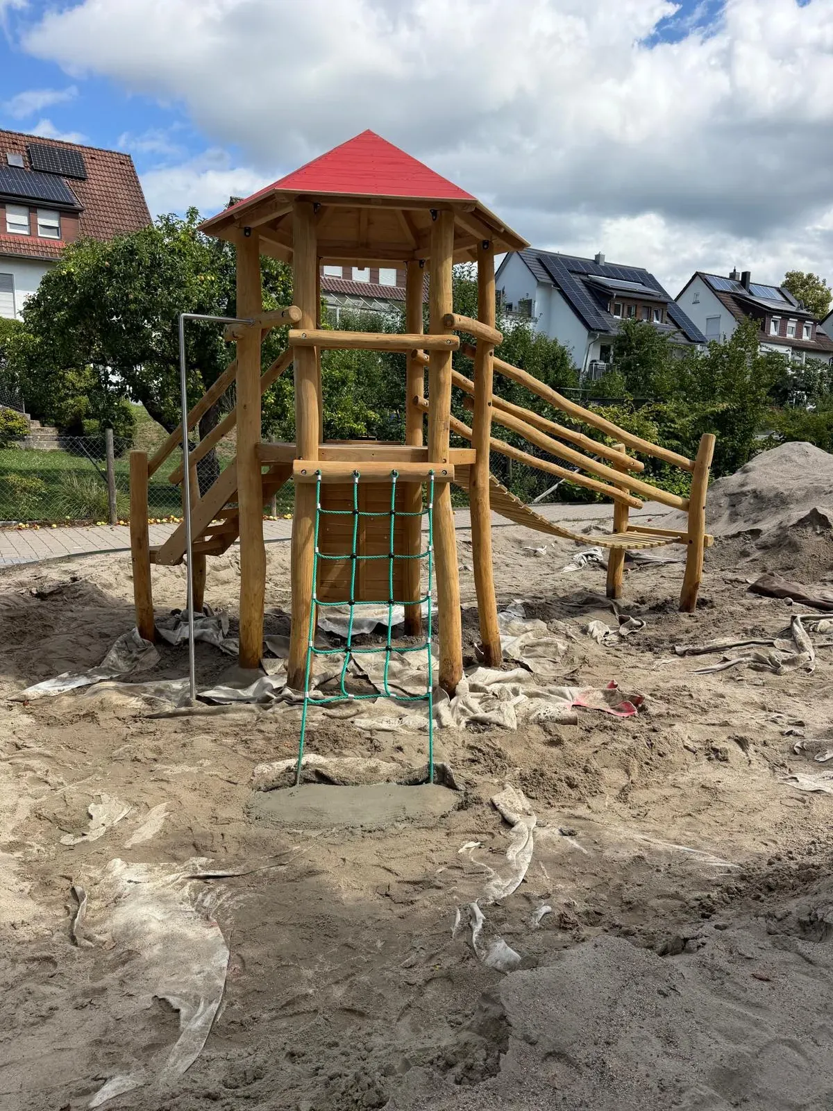 Holz-Spielturm mit Treppe und rotem Dach, montiert von Moshrif Spielplatzbau in Wiesbaden